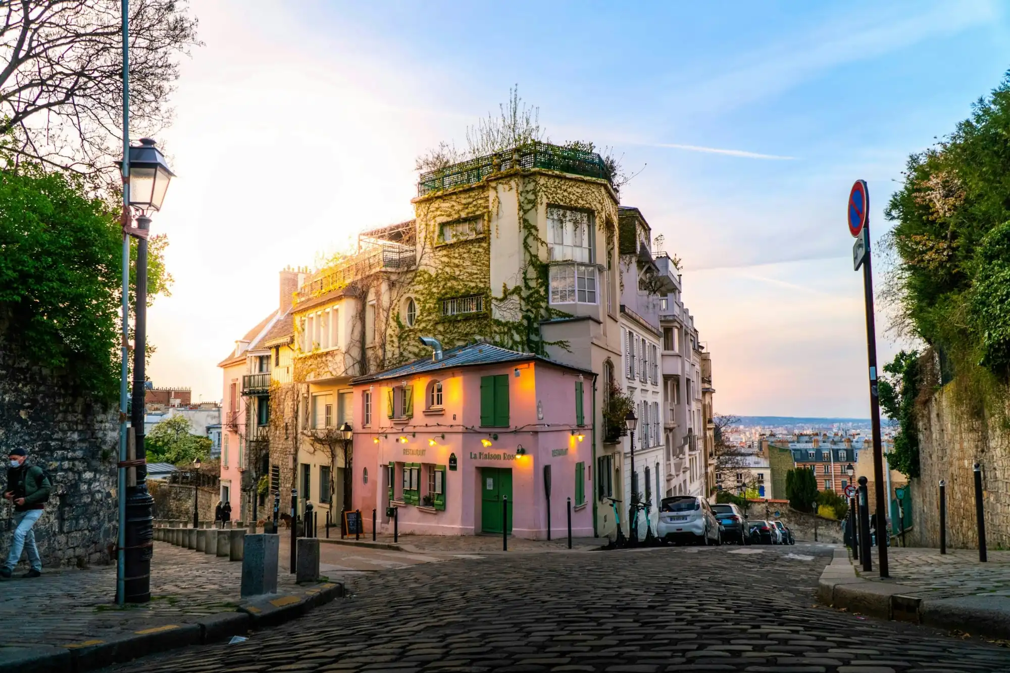 La Maison Rose à l’angle d’une rue pavée de Montmartre, Paris 18e, en fin de journée